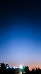 Venus and crescent Moon clearly visible in the evening sky at dusk above farmhouse in Kabd, Kuwait - Dec 27, 2019