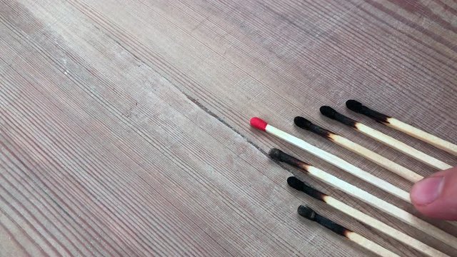 Leadership, career opportunities, education and success concept. Burned matches on wood texture background