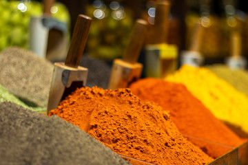 Many different spices in the eastern market. Ground peppers on the counter in a spice store.