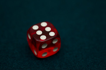 One red dice on green casino table close up. casino concept