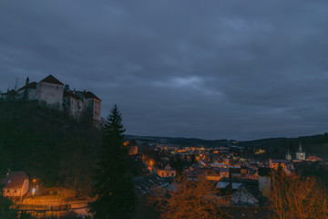 Fototapeta na wymiar View over Vimperk town in winter dark cold evening with castle