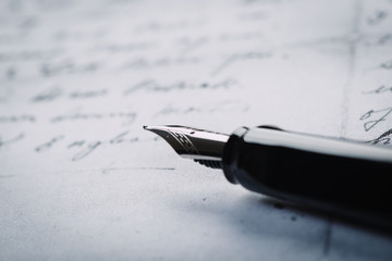 Fountain pen on an ancient handwritten letter. Old story. Retro style.
