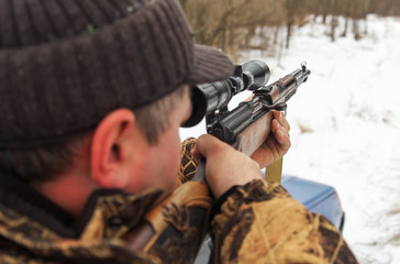 Winter hunting. Hunter moving With rifle and Looking For Prey.