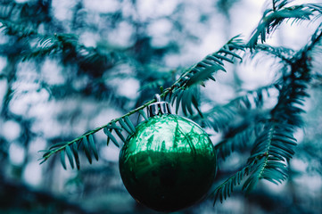Christmas tree ball on a Christmas tree in the forest with branches and a green look