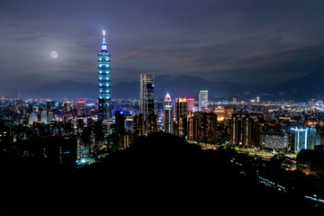 Naklejka premium Full moon city skyline, with taipei 101 tower in taiwan, skyscraper buildings night sky