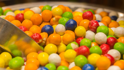 Fototapeta na wymiar PARIS, FRANCE - December 16, 2019: Close up / Macro of colorful gumballs in a bowl. Delicious & sweet confectionery. Colors include orange, yellow, blue, green, red and white. Popular with kids, 