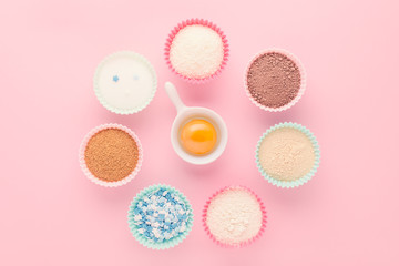 ingredients like a clock, baking time concept, on pink background