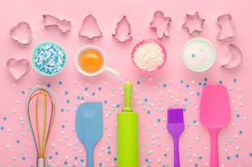 ingredients for baking and kitchen tools with cookie cutter on pink background, flat lay