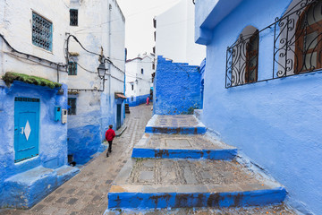 Traditional typical moroccan architectural details in Chefchaouen, Morocco, Africa Beautiful street of blue medina with blue walls and decorated with various objects (pots, jugs). A city with narrow, 