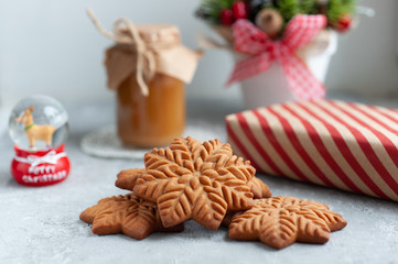 Obraz na płótnie Canvas gingerbread cookie in the form of stars with christmas gifts and with a jar of salted caramel on a white background with christmas composition