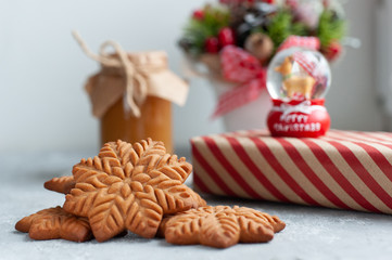  gingerbread cookie in the form of stars with christmas gifts and with a jar of salted caramel on a white background with christmas composition