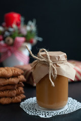 Fototapeta na wymiar jar of salty caramel with Christmas gifts with New Year's composition