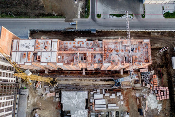 Construction and construction of high-rise buildings, the construction industry with working equipment and workers. View from above, from above. Background and texture