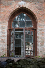 old window with broken glass and a wooden frame in a stone wall