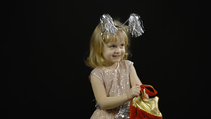 Happy beautiful little baby girl in glossy dress. Christmas. Make faces, dance