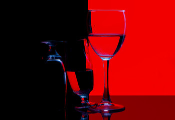 glass of red wine and bottle on black background