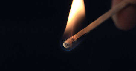 Firing up matches. Ignition lose-up detail of on matchbox and showing burning flame