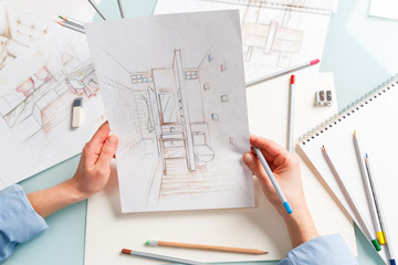 Interior designer holding hand drawing pencil sketch of a bathroom