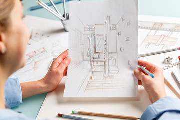 Interior designer holding hand drawing pencil sketch of a bathroom - 312420824