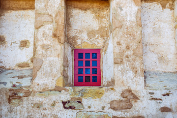 red window in an old stone wall