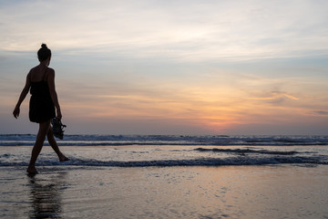 Girl walking on the water on a beach