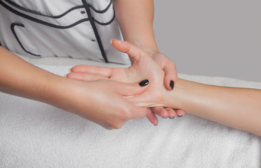Obraz na płótnie Canvas An orthopedic doctor does relaxing massage of the hand and arm of the patient after in the clinic. Cosmetology and massage concept.