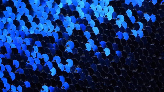 Moving sequins background. Holiday and festive texture. Blue sequins and glitter background.