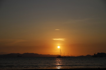 Sunset in the beach with a boat, Thailand 