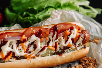Hot dogs with ketchup, mustard and vegetables on wooden table