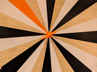 Wooden round Darts toy with black stripes. Rotates around an axis. Background close-up.