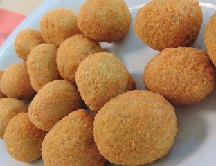Fried mozzarella cheese balls (mozarella fritta) on a white plate, close-up. Traditional Italian cuisine.