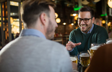 Friends in pub drinking beer and talking