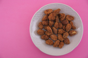 Top view of a plate with caramelized almonds with copy space
