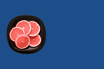 Coral orange in a plate on a blue background. Isolated background.