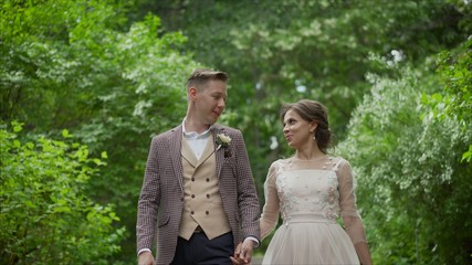 wedding couple in the park. bride and groom.love of two people.bride and groom hugging and smyling at the wedding in nature. The bride and groom hug and walk in the park.