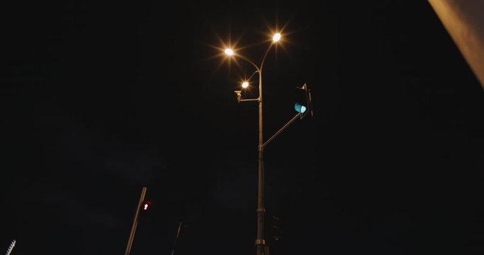 A bottom up view of lights changing at a crossroad, night time lapse of traffic, shot with BMPCC 4K