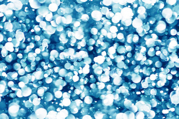 Blue bokeh shiny glitter background. Abstract vibrant color glowing white spots texture for graphic design.