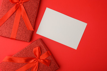 Valentine's Day, Flat lay. Red background with gifts, White card for congratulations on February 14. Postcard and congratulation.