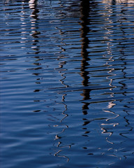 Sailboat masts reflection in harbor water