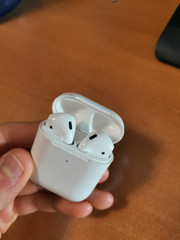 White wireless headphone pods in charging case.