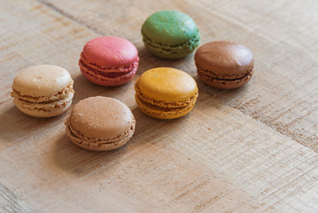 Traditional french colorful macarons in a row on table