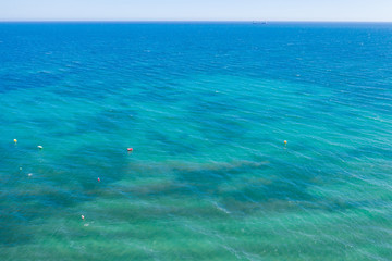 aerial view of the texture of the surface of turquoise water with sun reflections