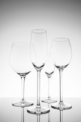 Glassware selection with wine, champagne and liquour glasses. Fine cristal glassware concept. Vertical, lightly toned