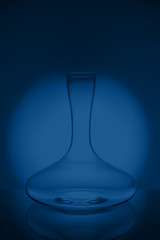 Luxury cristal decanter on classic blue background. Fine cristal glassware concept. Vertical,...