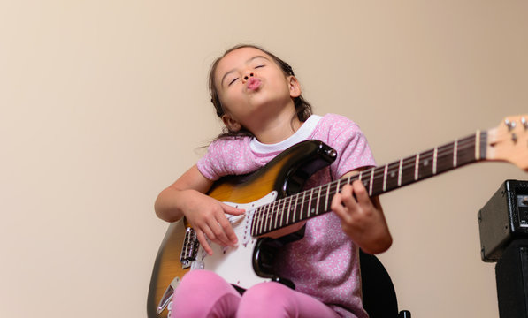 Beautiful Latin American Colombian Girl Practices Music On Her Electric Guitar