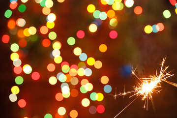 beautiful sparklers on the background of a garland. beautiful holiday card for the New Year.