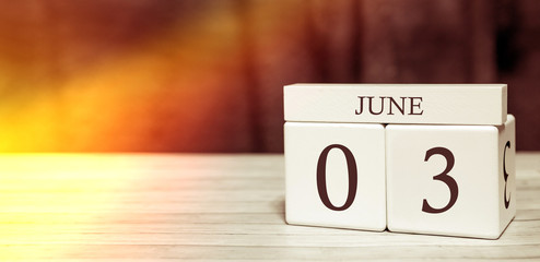 Calendar reminder event concept. Wooden cubes with numbers and month on June 3 with sunlight.