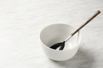 Empty bowl and spoon on light background