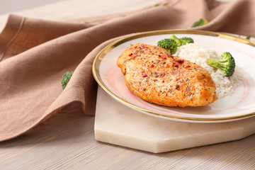 Plate with tasty rice and chicken on table
