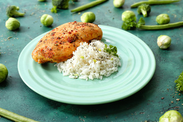 Plate with tasty rice, chicken and vegetables on color background